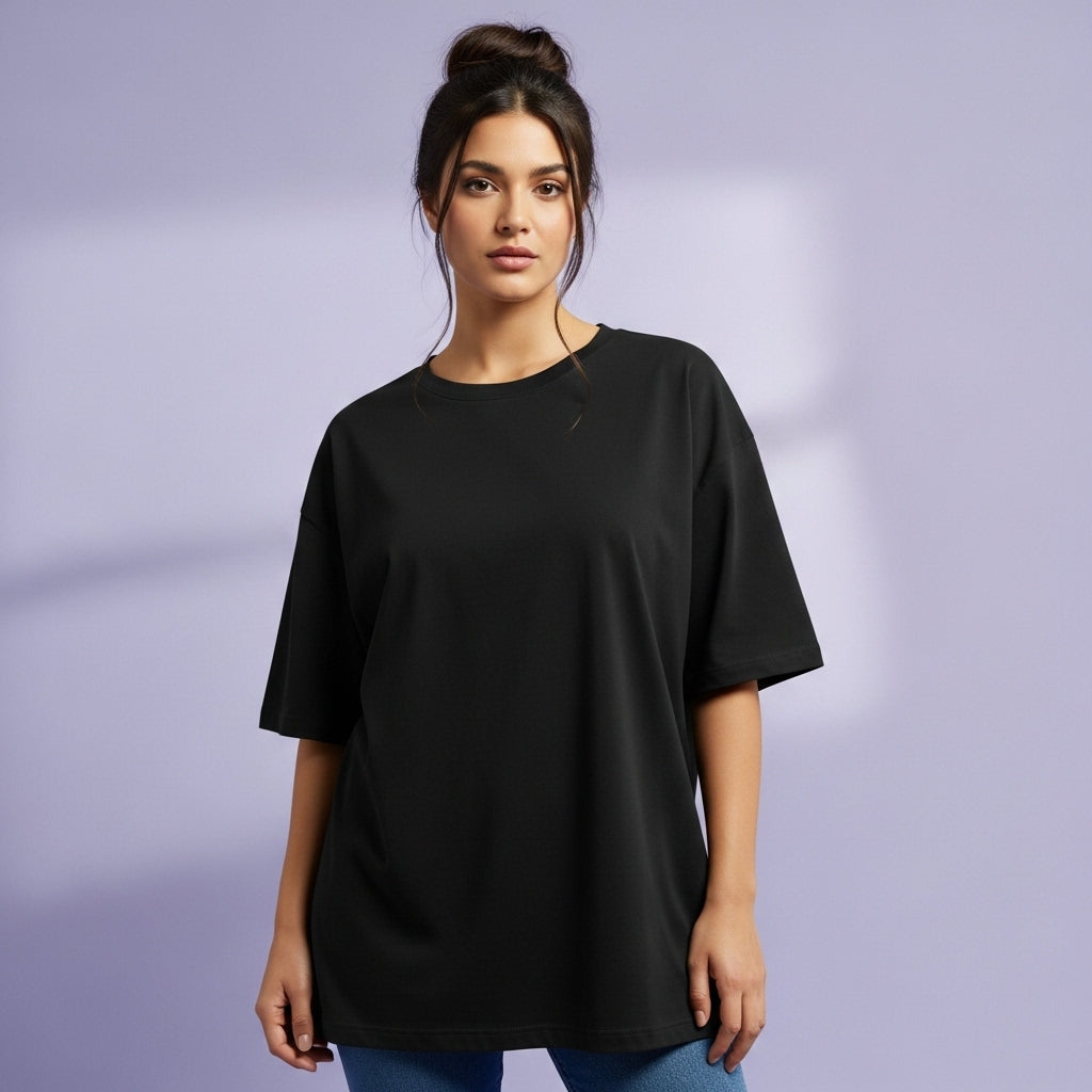 Woman wearing a black oversized t-shirt against a plain background